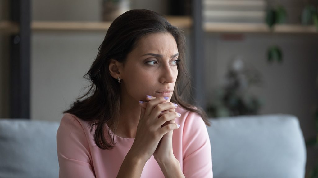 A woman sitting looking worried