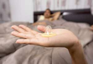 a woman holds a condom