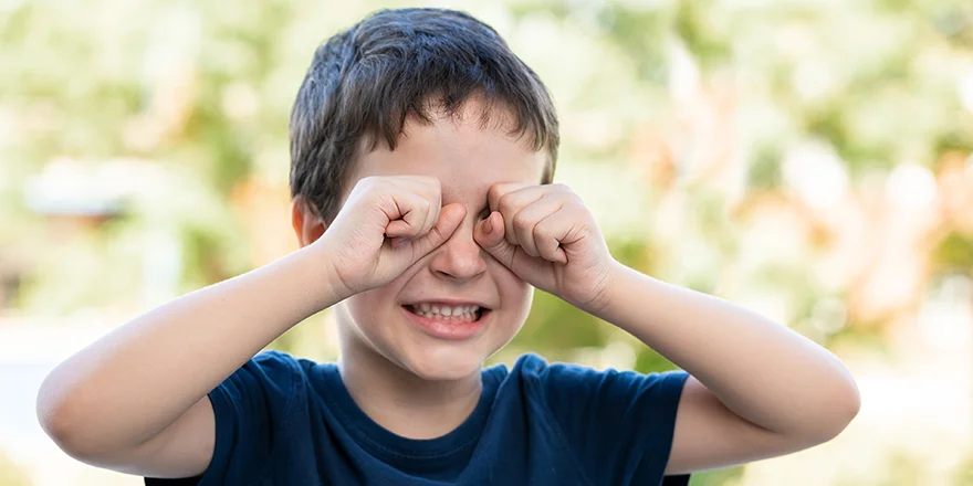 child rubbing eyes